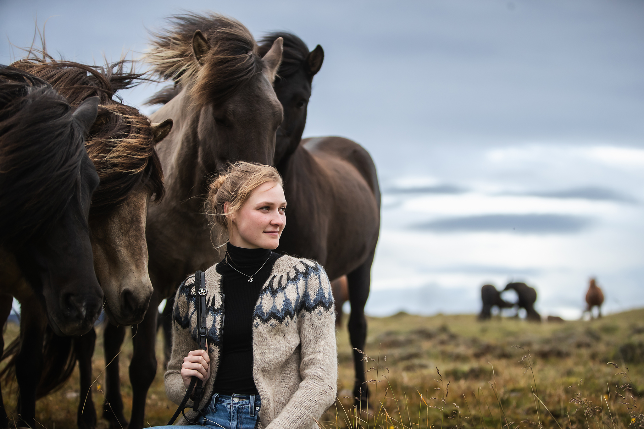 deutschsprachige Reitführerin mit Islandpferden in offener Landschaft während einer Tour auf Island