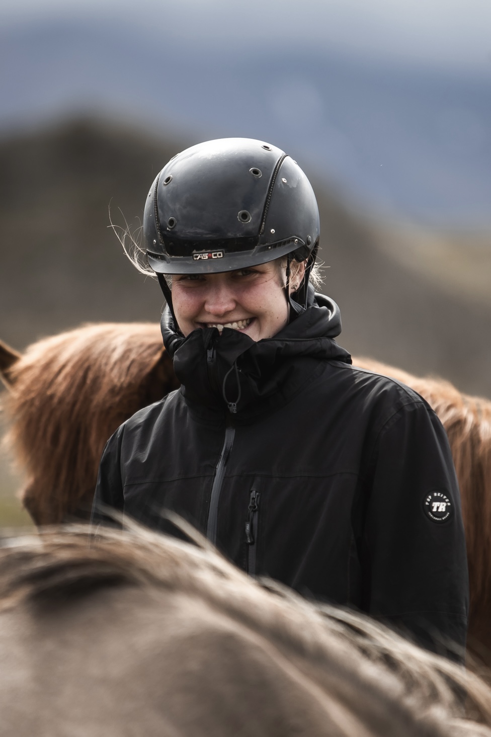deutschsprachige Reitführerin mit Islandpferden in offener Landschaft während einer Tour auf Island